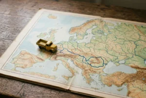 Mini camion sur une carte routière européenne, évoquant les déplacements et le détachement professionnel en Roumanie pour l’assurance travailleur détaché roumanie.