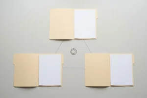 Trois dossiers reliés autour d’un anneau, suggérant une organisation de documents pour un contrat de mission temporaire.
